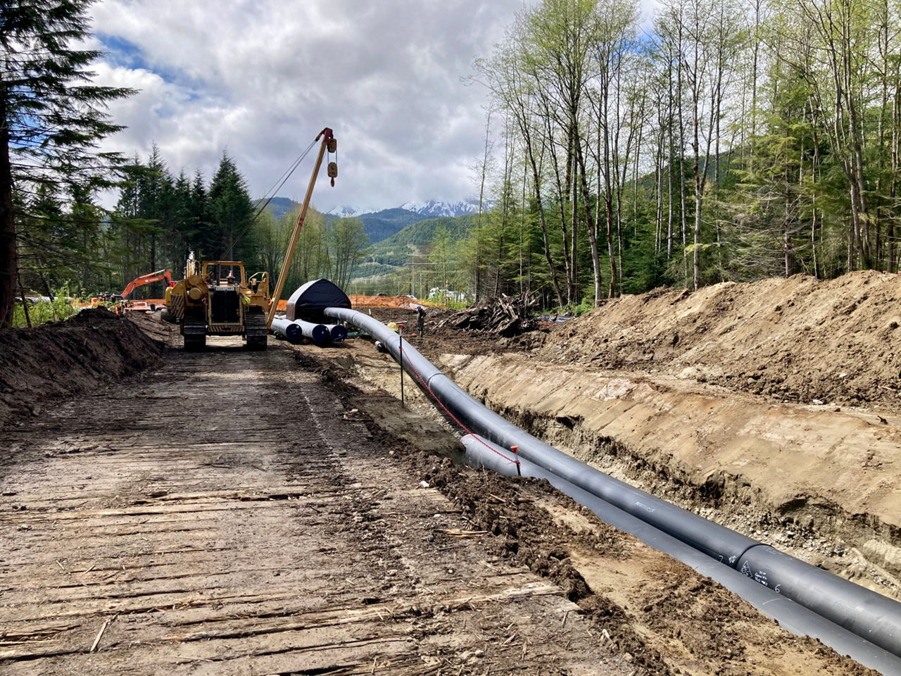 Vehicles at work and pipes being installed at a project site